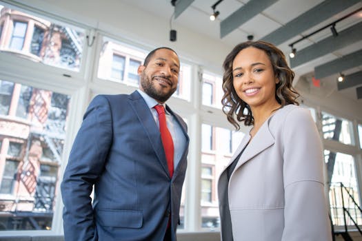 pexels-photo-1367269-1367269 Business professionals smiling in a modern Detroit office setting.