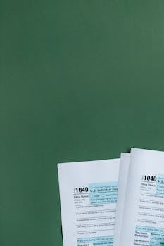 U.S. Tax Forms 1040 placed on a green surface, ideal for finance and taxation themes.