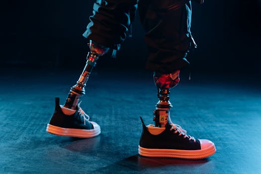 Close-up view of prosthetic legs wearing sneakers, highlighted by neon lights, showcasing modern technology and style.