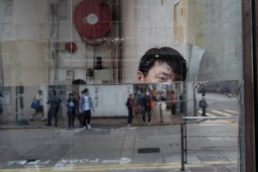 pexels-photo-19345556-19345556 Reflections of people and an individual in a rainy urban setting.