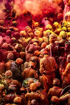 Colorful crowd celebrating Holi with vibrant powders in India.