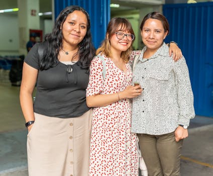 Three friends posing happily together indoors, showcasing friendship and joy.