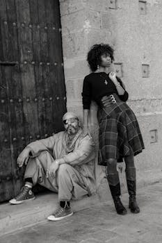 Black and white photo of two fashionable individuals posing by a historic door in Rabat, Morocco.