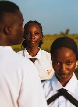 pexels-photo-35255764-35255764 Young students in uniform standing outdoors, looking confidently at the camera under bright daylight.